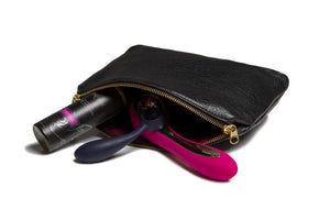 a black purse with a pink handle and a pair of scissors in it